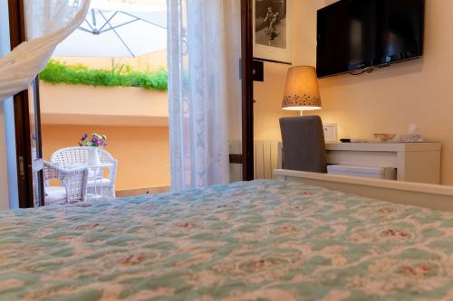 a bedroom with a bed and a tv and a window at B&B Le Sorelle in San Leone