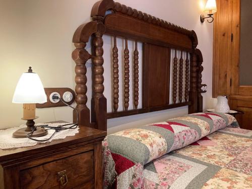 a bedroom with a wooden bed with a lamp on a dresser at B&B El Caminero in Hospital de Órbigo