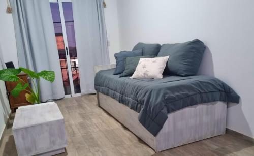 a bed with a blue blanket on it in a room at Departamento Sinsacate in Sinsacate