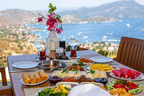 a table with plates of food on it with a view at Selimiye Lime Garden in Selimiye
