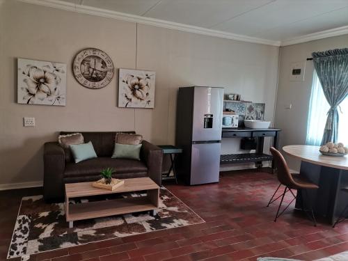 a living room with a couch and a refrigerator at DR M BEAUTY LOUNGE AND GUEST HOUSE in Bloemfontein