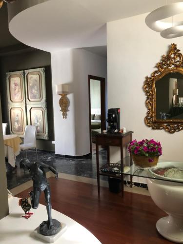 a room with a statue on a table and a mirror at Vicosuite Neathon in Noto