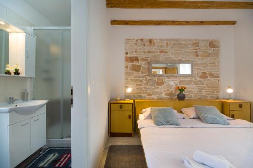 a bedroom with a bed and a stone wall at House Braida in Bale