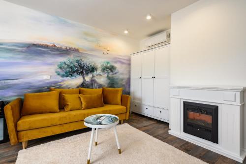 a living room with a yellow couch and a fireplace at Ponte Porton Dining & lodging in Grožnjan