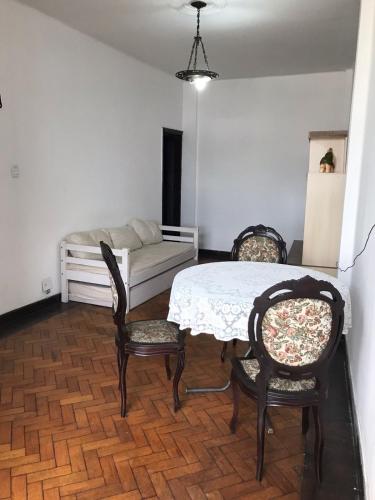 comedor con mesa, sillas y sofá en Apartamentozonasul, en Río de Janeiro