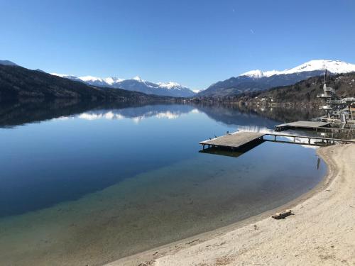 a body of water with a dock on a beach at Seeblick Millstatt in Millstatt