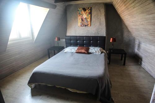 une chambre avec un grand lit dans un grenier dans l'établissement Maison avec vue magnifique, à Loubejac