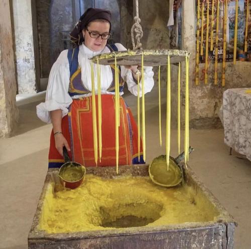 a woman is standing next to a mixing bowl at Le Corti Sarde Apartments in Bari Sardo