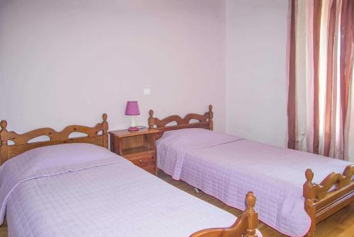スコペロスにあるAlexandra Metoxi Skopelosのベッドルーム(ツインベッド2台、テーブル上のランプ付)