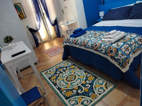 a bedroom with a bed and a table and a rug at Al Quindici Scilla in Scilla