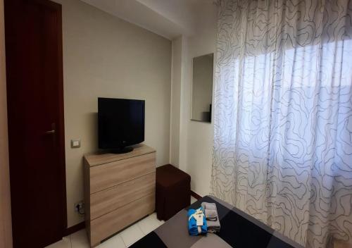 una camera con un letto e una TV su un comò di CASA SOFIA Via Amerigo Vespucci n18 a Roccalumera