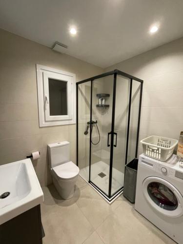 a bathroom with a shower toilet and a washing machine at Chalet del Sol en El Faro in Mijas Costa