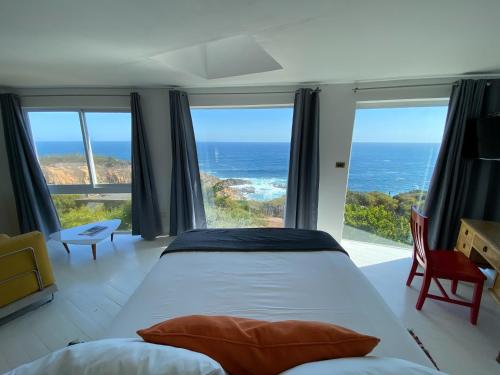 a bedroom with a bed and a view of the ocean at Tunquen Magico in Tunquén