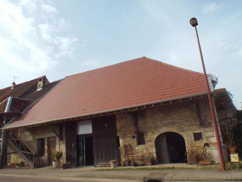 a large brick building with a red roof at la forge du Prosper et de sa Prosperine in Cramans