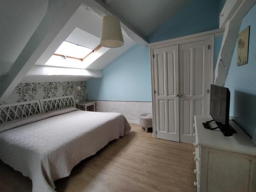 a bedroom with a bed and a tv and a window at Hotel Casona del Sella in Arriondas