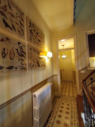 a hallway with a white radiator and paintings on the wall at Hotel Casona del Sella in Arriondas