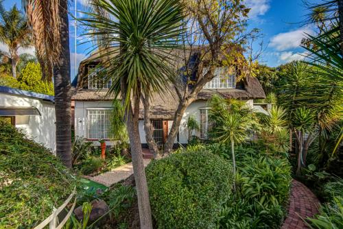 een huis met palmbomen ervoor bij Lavender Villa No loadshedding in Kempton Park