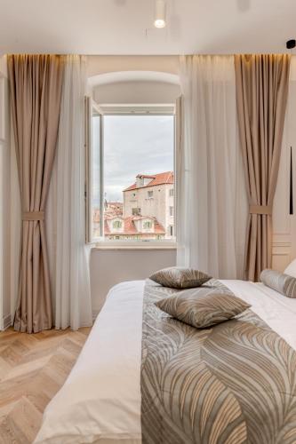 a bedroom with a bed and a large window at Luxury Rooms L'Avenue 2 Split in Split