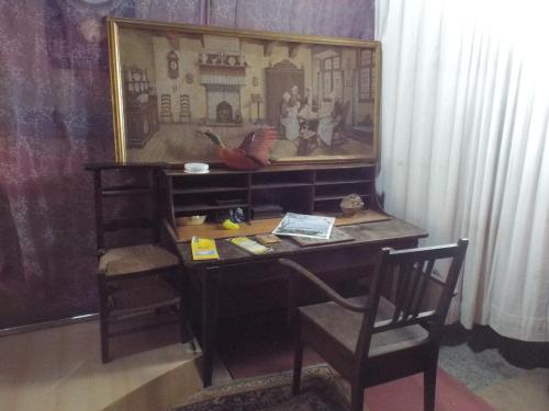 un escritorio en una habitación con una foto en la pared en la forge du Prosper et de sa Prosperine, en Cramans