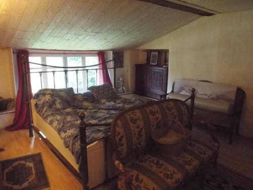 1 dormitorio con 1 cama, 1 silla y 1 ventana en la forge du Prosper et de sa Prosperine, en Cramans