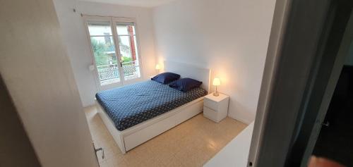 une petite chambre avec un lit et une fenêtre dans l'établissement Appartement entier au dessus de villa, climatisation réversible poêle à bois tres chaleureux , wi fi parking privée gratuit situation 500 m, plage et centre ville, à Sanary-sur-Mer