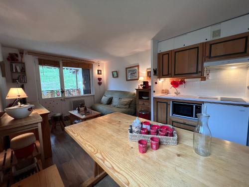 Il comprend une cuisine et un salon avec une table en bois. dans l'établissement Parnasse 413 - Appartement centre, à La Clusaz