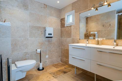 a bathroom with a toilet and a sink and a mirror at Domaine de l'Aufrene in Hyères