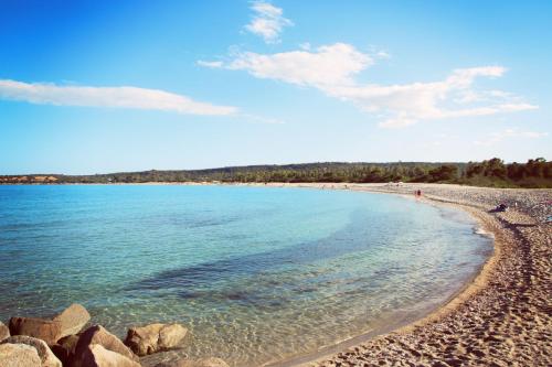a view of a beach with rocks in the water at Le Corti Sarde Apartments in Bari Sardo