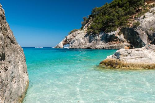 a view of a beach with rocks and the ocean at Le Corti Sarde Apartments in Bari Sardo