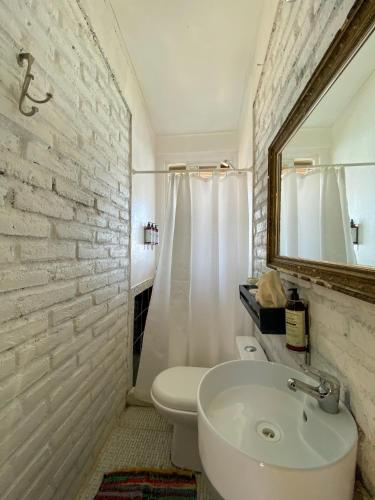 a bathroom with a white toilet and a sink at Tunquen Magico in Tunquen