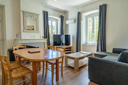 a living room with a table and a couch at Domaine de l'Aufrene in Hyères