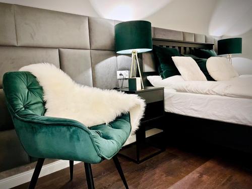 a bedroom with a green chair and a bed at DeerHome Apartment in Czarny Dunajec