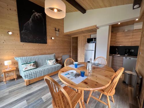 une cuisine et une salle à manger avec une table et des chaises dans l'établissement Sapaudia G - Appartement skis aux pieds, belle vue, à La Clusaz