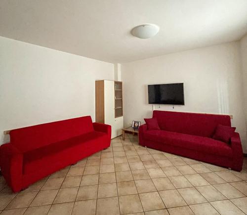 a living room with two red couches and a flat screen tv at Richi Rent 01 in Verona