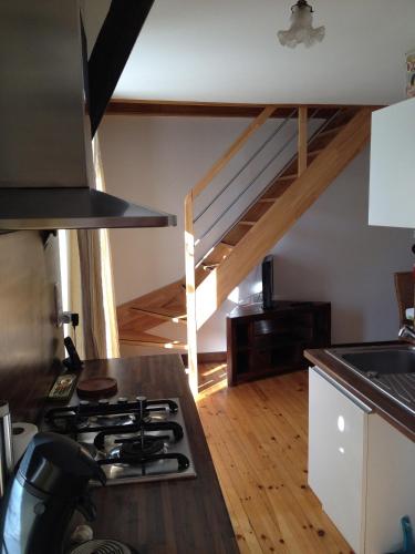 d'une cuisine avec une cuisinière et une mezzanine. dans l'établissement LES GITES D'AVEZE, à Avèze