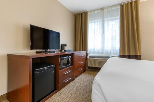 a hotel room with a flat screen tv and a bed at Wingate by Wyndham Los Alamos in Los Alamos