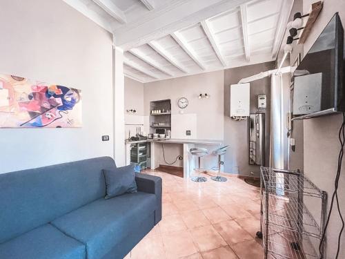 sala de estar con sofá azul y cocina en MYHOUSE INN LE ROSINE - Affitti Brevi Italia, en Turín