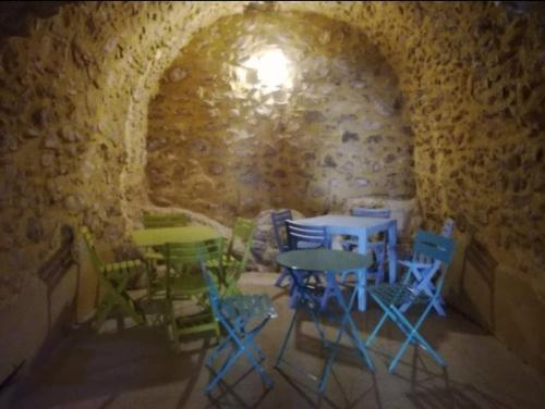 un grupo de mesas y sillas en una habitación de piedra en Gîte d'étape de Vitrolles en Luberon, en Vitrolles-en-Luberon