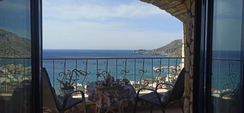 a balcony with a table and a view of the ocean at Elouthia Residence with Sea View and Hot Tub in Tsoútsouros