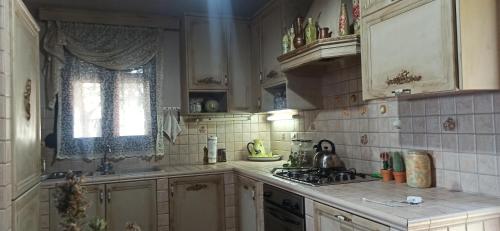 a kitchen with a sink and a stove top oven at Elouthia Residence with Sea View and Hot Tub in Tsoútsouros