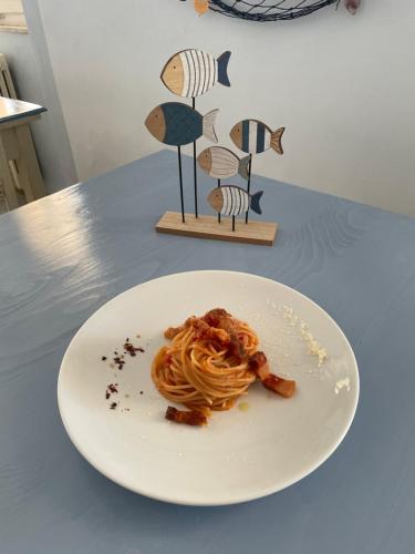 a white plate of pasta on a table at Hotel Eden in Follonica