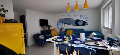 een woonkamer met een tafel en blauwe stoelen bij Bulle Marine in Calais