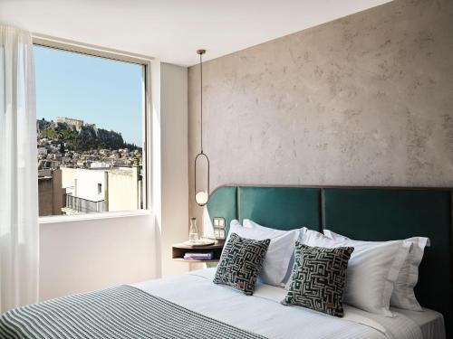 a bedroom with a bed with a large window at The Lekka Hotel & Spa in Athens