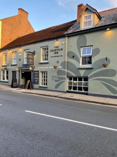 un edificio sul lato di una strada di The Fountain Inn & Riverside Restaurant a Okehampton