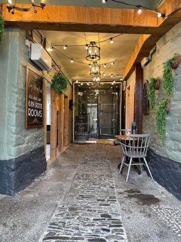 un passaggio che conduce a un ristorante con tavolo di The Fountain Inn & Riverside Restaurant a Okehampton