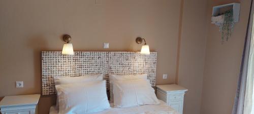 a bed with two pillows and two lights above it at Cactus Mini in Nydri