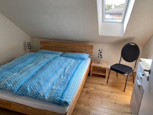 ein Schlafzimmer mit einem Bett, einem Stuhl und einem Fenster in der Unterkunft Ferienwohnung Grenzblick in Isselburg-Anholt in Isselburg