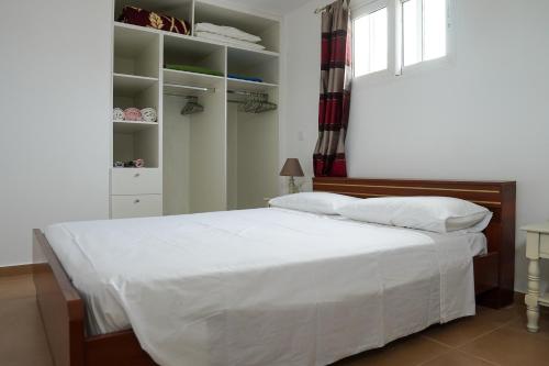 una camera da letto con un grande letto bianco e una finestra di Aelia House a Città di Kos