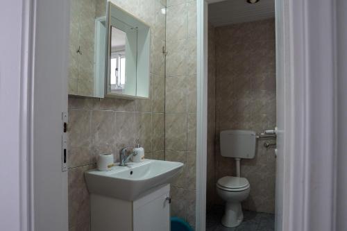 a bathroom with a sink and a toilet and a mirror at Aelia House in Kos