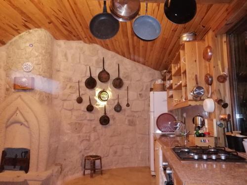 a kitchen with pots and pans hanging from the ceiling at patisca cave house in cappadocia in Urgup